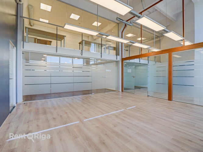 A spacious and bright loft-style office featuring an open-plan workspace and separate private office Рига - изображение 1
