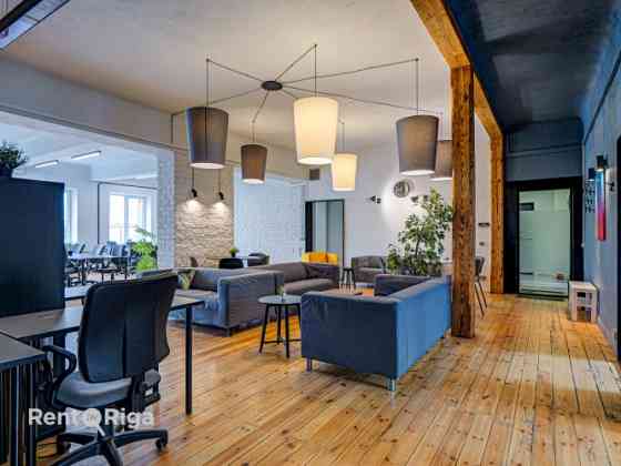 Office with a creative industrial atmosphere  high ceilings, wooden plank floors, exposed wooden bea Рига