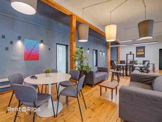 Office with a creative industrial atmosphere  high ceilings, wooden plank floors, exposed wooden bea Рига