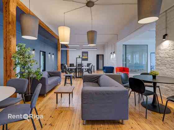 Office with a creative industrial atmosphere  high ceilings, wooden plank floors, exposed wooden bea Рига