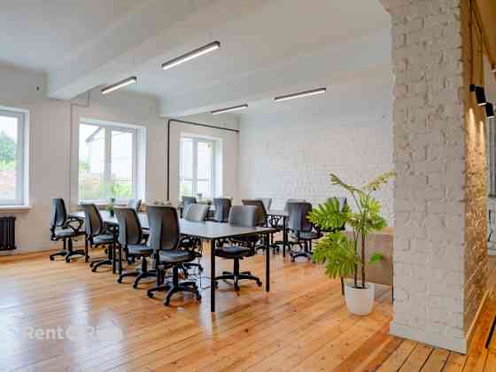 Office with a creative industrial atmosphere  high ceilings, wooden plank floors, exposed wooden bea Рига