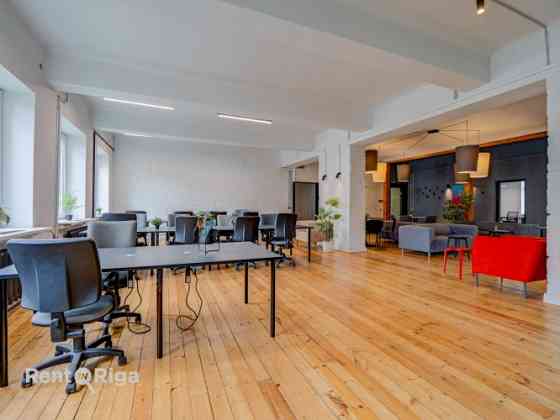Office with a creative industrial atmosphere  high ceilings, wooden plank floors, exposed wooden bea Рига